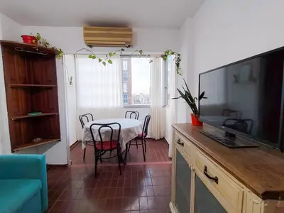 a living room with a table and a television at El Depto del Rey in Cordoba