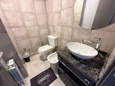 a bathroom with a sink and a toilet and a mirror at Edificio Catalina in Villa Carlos Paz