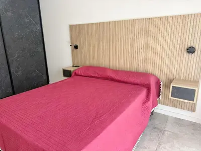 a bed with a pink bedspread in a room at Edificio Catalina in Villa Carlos Paz