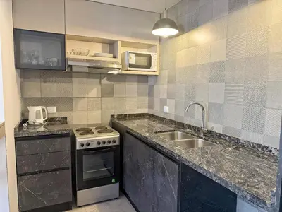 a kitchen with a sink and a stove at Edificio Catalina in Villa Carlos Paz