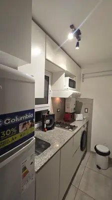 a kitchen with white cabinets and a stove top oven at Departamento Nueva Córdoba - Parque Sarmiento in Cordoba