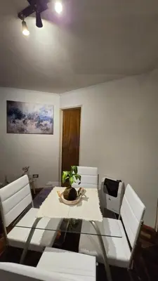 a dining room with a table and white chairs at Departamento Nueva Córdoba - Parque Sarmiento in Cordoba