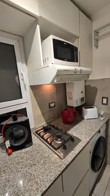 a kitchen with a microwave and a stove top oven at Departamento Nueva Córdoba - Parque Sarmiento in Cordoba