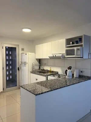 a kitchen with white cabinets and a counter top at Torres H Güemes in Cordoba