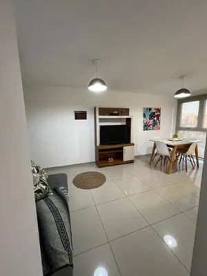 a living room with a tv and a table with chairs at Torres H Güemes in Cordoba