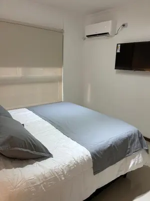 a bedroom with a bed with a television on the wall at Departamento Venetto 8 in Villa Carlos Paz