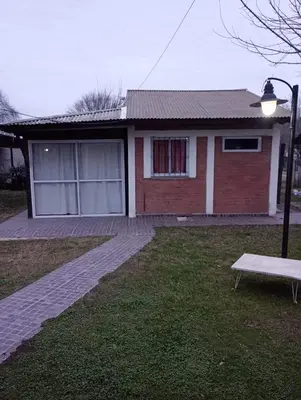 a house with a bench in front of it at Cabañas Los Abuelos in Santa Rosa de Calamuchita