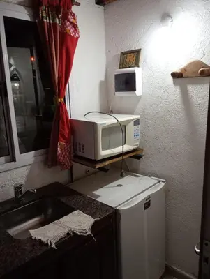 a kitchen with a microwave on top of a counter at Cabañas Los Abuelos in Santa Rosa de Calamuchita