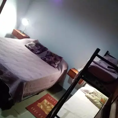 a small bedroom with a bed and a table at Cabañas Los Abuelos in Santa Rosa de Calamuchita
