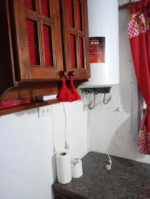 a kitchen with a cupboard and two rolls of toilet paper at Cabañas Los Abuelos in Santa Rosa de Calamuchita