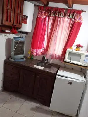 a small kitchen with a sink and a microwave at Cabañas Los Abuelos in Santa Rosa de Calamuchita