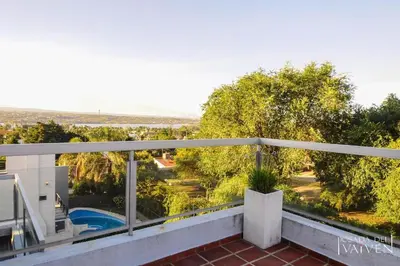 a balcony with a view of a pool and trees at Del Vaiven in Villa Carlos Paz