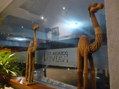 a pair of wooden giraffes standing in a window at Del Vaiven in Villa Carlos Paz
