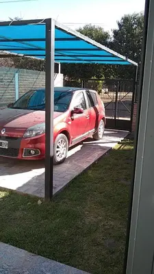 a red car parked under a blue canopy at Los Horneros in Villa Cura Brochero