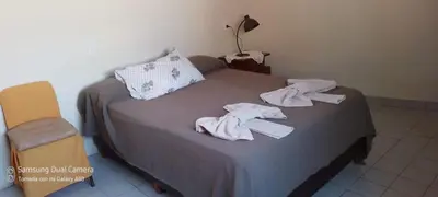 a bed with towels on it with a chair at Los Horneros in Villa Cura Brochero