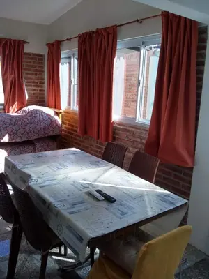 a room with a table with chairs and a bed at Los Horneros in Villa Cura Brochero
