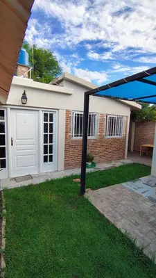 a garage with a white door and a brick house at Los Horneros in Villa Cura Brochero
