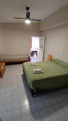 a bedroom with a green bed and a window at Los Horneros in Villa Cura Brochero