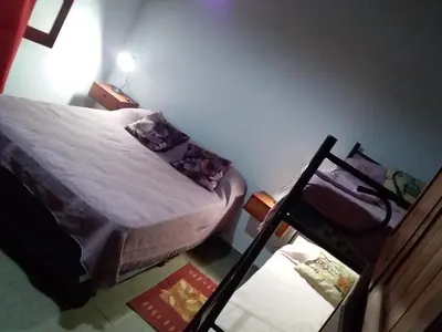 a small bedroom with a bed and a chair at Cabañas Los Abuelos in Santa Rosa de Calamuchita