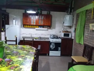 a kitchen with a white refrigerator and a stove at Cabañas Los Abuelos in Santa Rosa de Calamuchita