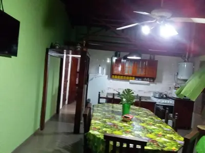a dining room with a table and a kitchen at Cabañas Los Abuelos in Santa Rosa de Calamuchita