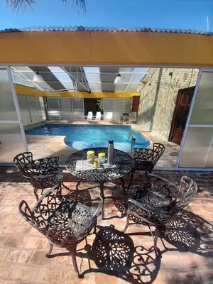 a patio with a table and chairs next to a swimming pool at Cabañas Pinares al Alba in Almafuerte