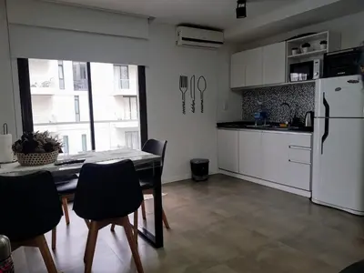 a kitchen with a table and chairs and a refrigerator at Departamento Lake Towers in Villa Carlos Paz