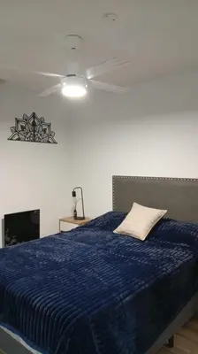 a bedroom with a blue bed with a ceiling fan at Departamento Lake Towers in Villa Carlos Paz