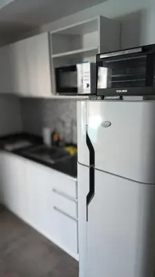 a white refrigerator with a microwave on top of it at Departamento Lake Towers in Villa Carlos Paz