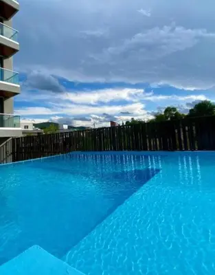 a large blue swimming pool next to a fence at Departamento Lake Towers in Villa Carlos Paz