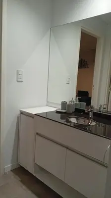 a white kitchen with a counter and a mirror at Departamento Lake Towers in Villa Carlos Paz