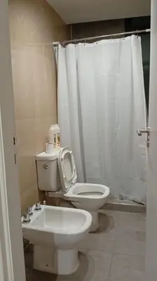 a bathroom with a white toilet and a sink at Departamento Lake Towers in Villa Carlos Paz
