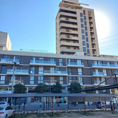 a building with a bus stop in front of it at Departamento Lake Towers in Villa Carlos Paz