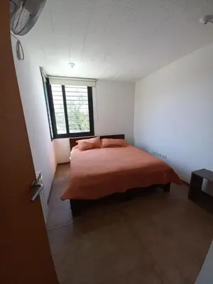 a bedroom with a bed in a room with a window at CuyenCo in Santa Rosa de Calamuchita