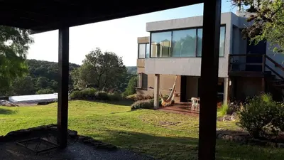 a glass house with a view of a yard at CuyenCo in Santa Rosa de Calamuchita