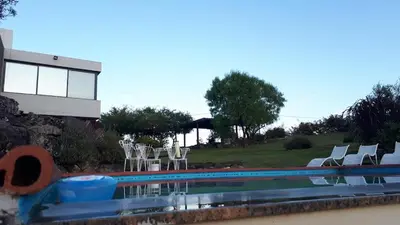 a swimming pool with a bunch of chairs around it at CuyenCo in Santa Rosa de Calamuchita