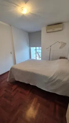a bedroom with a white bed and a wooden floor at Espacio C Obispo Salguero in Cordoba