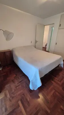 a large bed in a room with a wooden floor at Espacio C Obispo Salguero in Cordoba
