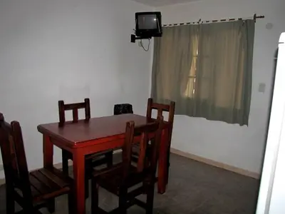 a room with a table and chairs and a television at Complejo Steffen in Merlo