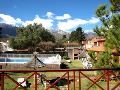 a resort with a pool and mountains in the background at Complejo Steffen in Merlo