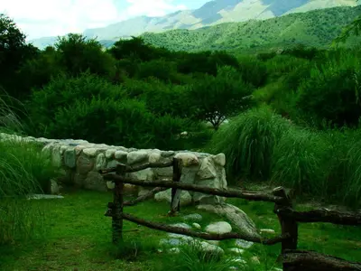 a wooden fence in a field with mountains in the background at Posada La Valentina in Villa de Las Rosas