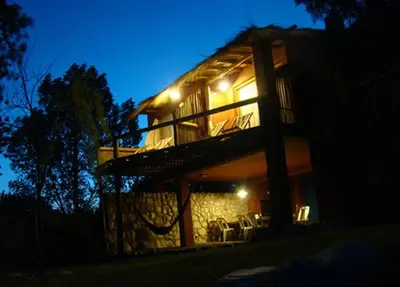 a house with lights on the side of it at night at Posada La Valentina in Villa de Las Rosas