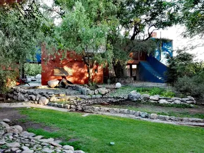 a garden with a stone fire pit in the yard at Posada La Valentina in Villa de Las Rosas