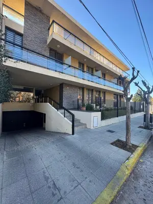 a building with a parking lot in front of it at Carlos Paz Roque Sainz Peña in Villa Carlos Paz