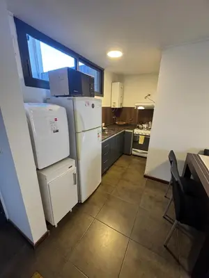 a kitchen with a white refrigerator and a window at Carlos Paz Roque Sainz Peña in Villa Carlos Paz