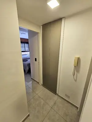 a hallway with a phone on the wall and a bedroom at Chic in Cordoba