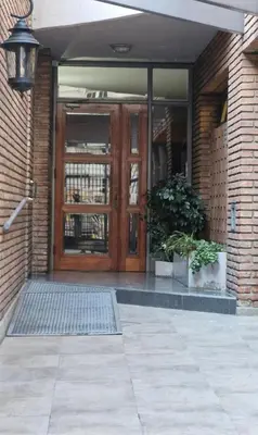 a front door of a brick building with two potted plants at Chic in Cordoba