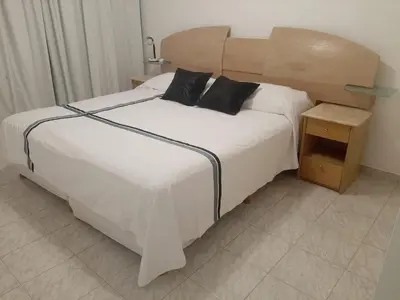 a bedroom with a large white bed with a wooden headboard at 1º A y 2º A in Cordoba