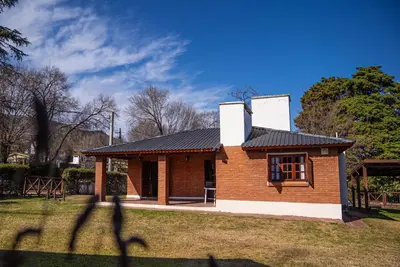 a small brick building with a black roof at Cabañas Montecarlo 1 in Santa Rosa de Calamuchita