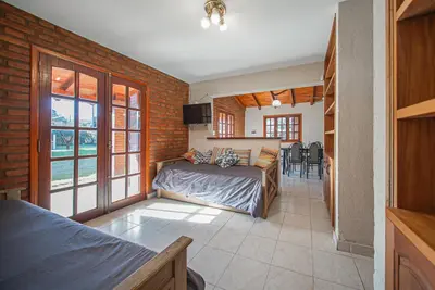 a bedroom with a bed and a living room at Cabañas Montecarlo 1 in Santa Rosa de Calamuchita